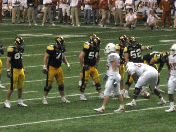 Football players in black and yellow uniforms on a green field
