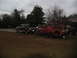 1952 Ford Pickup - A red tow truck transports a black SUV on a trailer under an overcast sky.