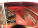 1952 Ford Pickup - Interior view of a red pickup truck, showing the dashboard, seat, and door panel.