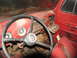 1952 Ford Pickup - The interior of a red 1952 Ford Pickup shows its dashboard, steering wheel, and seats, indicating a vintage vehicle.
