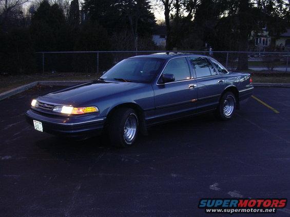 1996 Ford Crown Victoria sedan parked in a lot at dusk