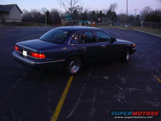 Dark blue 1995 Ford Crown Victoria with chrome wheels parked on asphalt