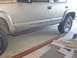 2000 Chevrolet Tahoe - A silver Chevrolet Tahoe is shown from the side, with its running boards and tires visible.