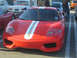 1985 Ford Mustang - A red Ferrari 360 Modena with racing stripes is parked at a car show.
