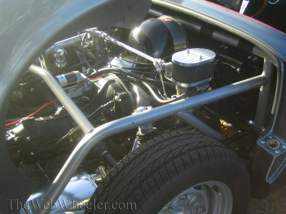 Engine bay with roll cage, air filter, and tire visible. Gray exterior paint