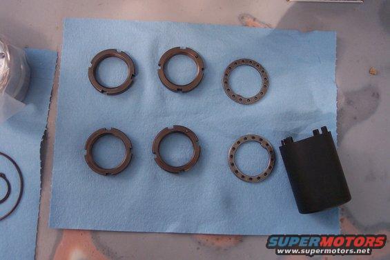 Several hub lock rings and a black plastic cap on a blue shop towel