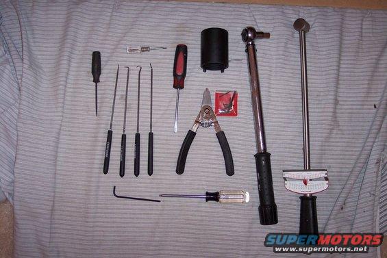Torque wrenches, screwdrivers, and picks laid out on a striped cloth