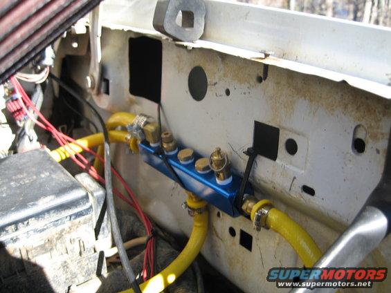 This is the manifold I put in.  The hose that goes into the bottom of the manifold is from the compressor.  Two outlets are plugged.  The right most outlet has the saftey pop off valve and the line that runs to the front.  The leftmost outlets includes the fitting that goes to the gauge and the drain valve.  The other hose on the left of the manifold goes to the rear of the truck.  