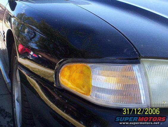 Black 1995 Ford Mustang front corner with amber turn signal and clear headlight