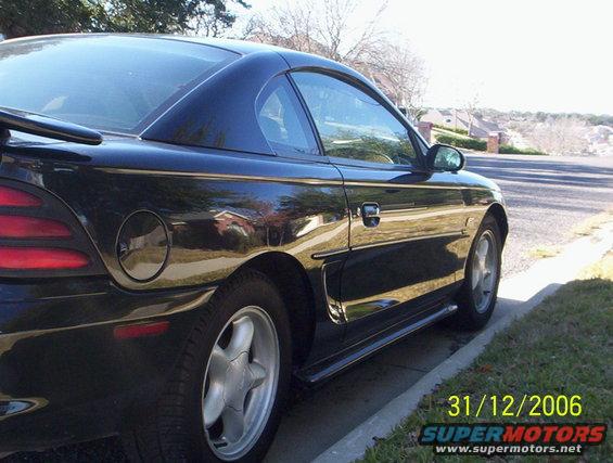1995 Ford Mustang coupe, side view, parked on curb