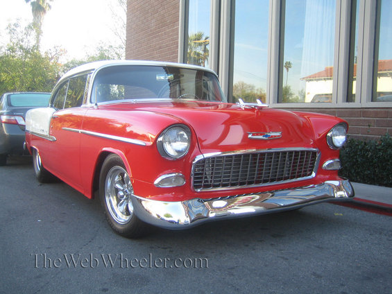 Red and white 1955 Chevrolet Bel Air parked outside