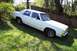 1985 Ford Crown Victoria LTD - White 1985 Ford Crown Victoria LTD parked on a grassy slope next to a wooden fence.