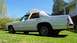 1985 Ford Crown Victoria LTD - This white sedan is parked on a grassy lawn with a house in the background under a clear blue sky.