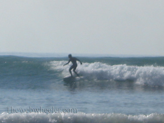 Surfer riding a wave with the ocean and sky in the background