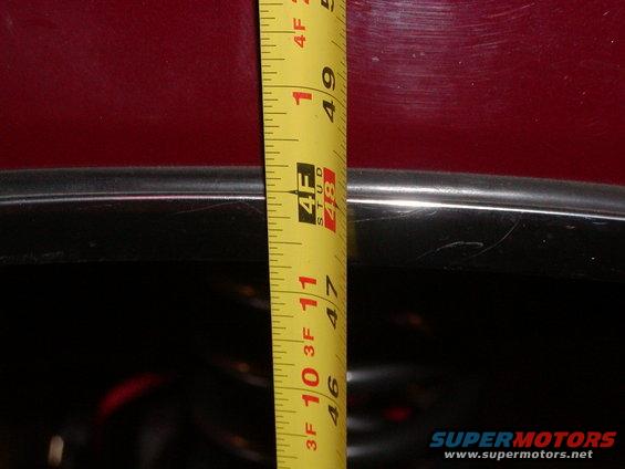 Red vehicle body with tape measure showing 49 inches