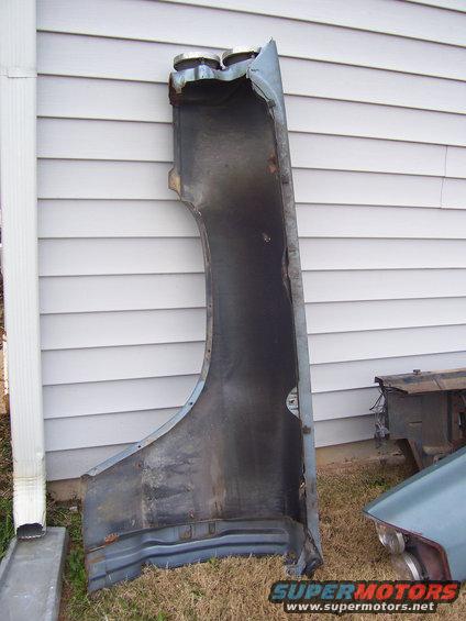 Fender part against a vinyl-sided wall