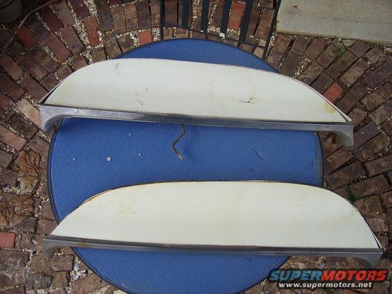 Two white and chrome car trim pieces on a blue table