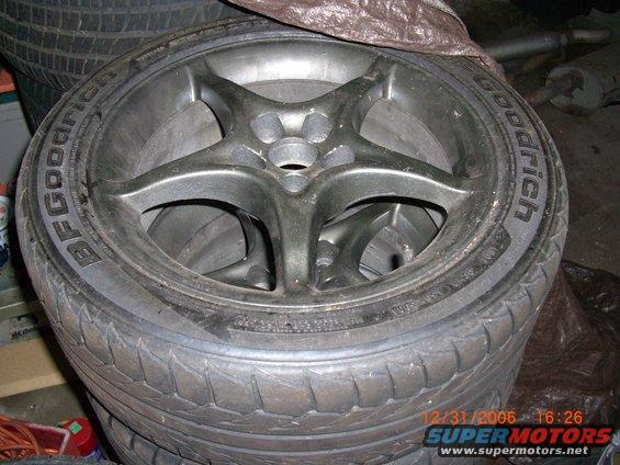 Stack of BFGoodrich tires with five-spoke alloy wheels on them