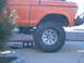 1978 Ford Bronco - This orange 1978 Ford Bronco features a lifted suspension and oversized tires, suggesting off-road modifications.