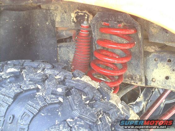 Red coil spring and shock absorber on a vehicle's suspension
