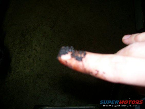 finger covered in black gunk