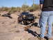 1984 Ford Bronco - A black Ford truck tackles a challenging off-road course, with another off-road vehicle visible in the distance.