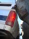 1984 Ford Bronco - A white SUV is tightly wedged between two large rocks, with its rear taillight and part of the body visible.