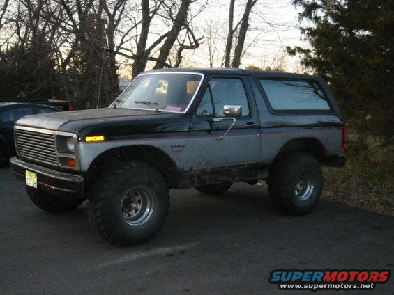 Black and grey SUV with large tires, 3/4 front view