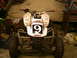 1977 Ford F-250 - Quad bike with racing graphics and number 9 is parked indoors.