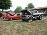 1970s pickup truck with hood open next to a red classic car