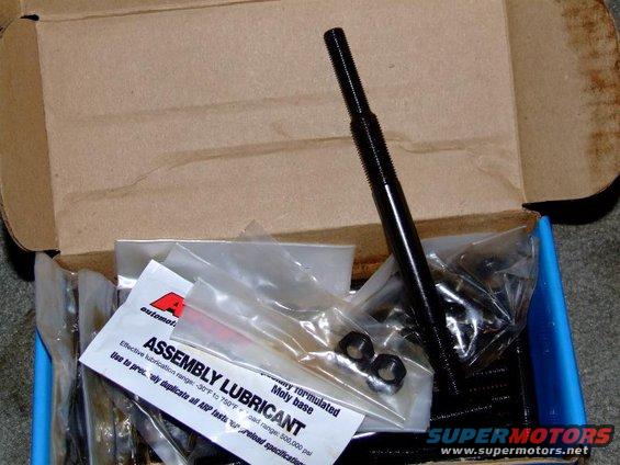 Box of engine assembly lubricant and hardware, including a long black bolt and two nuts