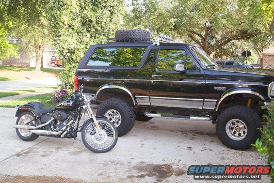 black Ford Bronco with a motorcycle parked next to it