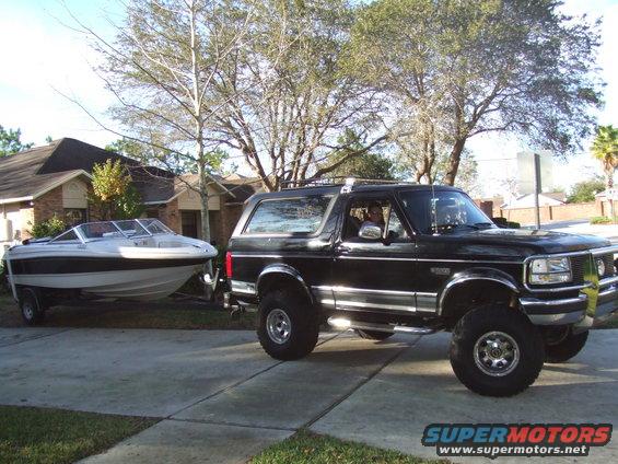 Black 1995 Ford Bronco towing a white boat