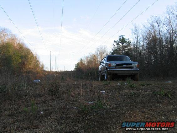 Gray Ford Bronco parked on a dirt hill with power lines overhead
