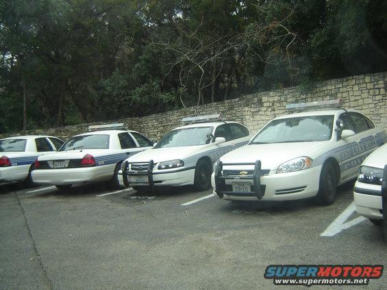 Several white police cars parked in a lot. One has "WEST LAKE HILLS POLICE" on the side