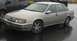 1990 Ford Taurus - Silver 1990 Ford Taurus sedan with aftermarket wheels parked on a wet surface.