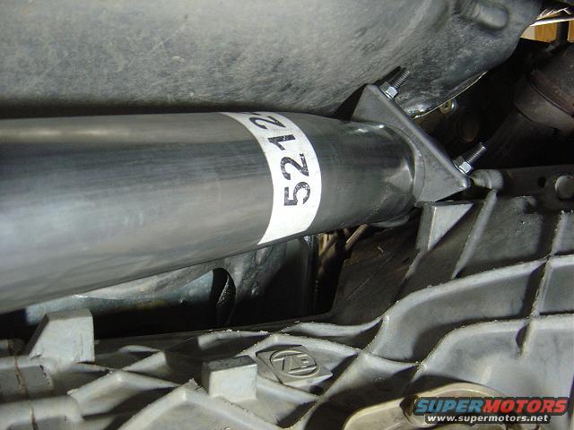 Close-up of exhaust pipe with a white band labeled '5212' and part of a transmission housing