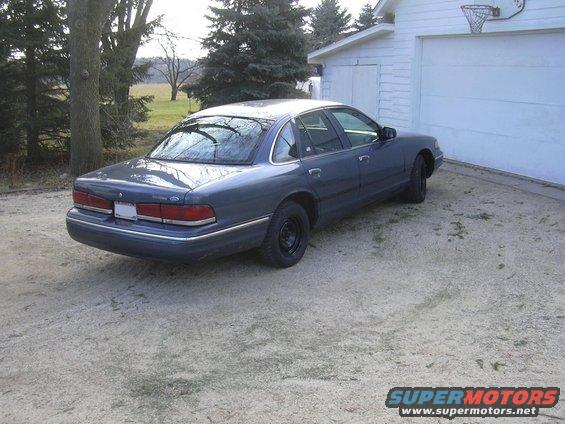 1996 Ford Crown Victoria parked on gravel next to a white garage