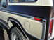 1979 Ford Bronco - The rear quarter panel of a two-tone brown and beige Ford Bronco shows its fuel door and taillight assembly.