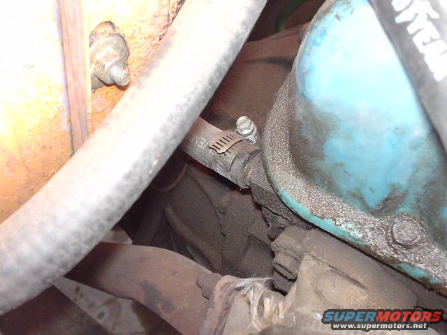 Close-up of engine parts, including hoses and a blue valve cover