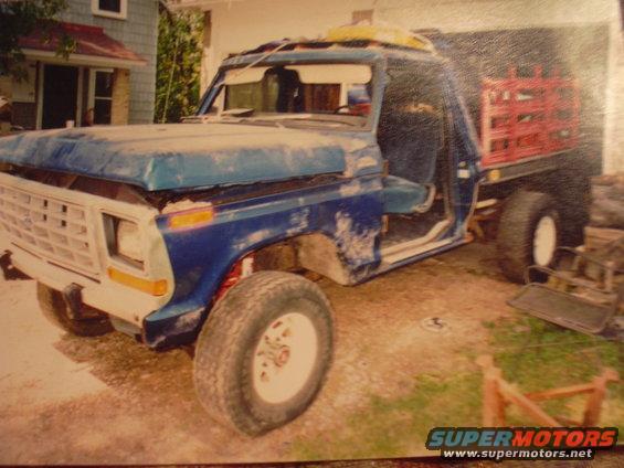 Blue 1977 Ford F-150 pickup truck with flatbed, missing doors and hood