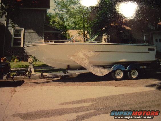 White boat on a dual-axle trailer parked on a street