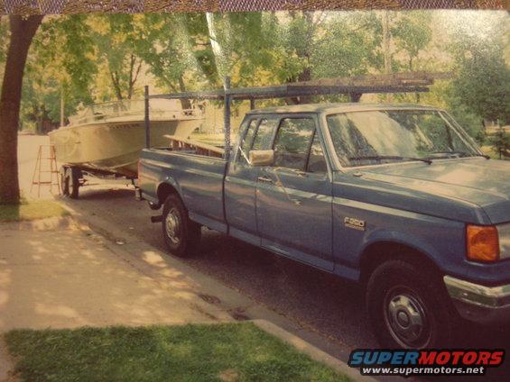 Blue pickup truck with a boat on a trailer behind it