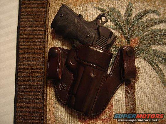 Pistol in a brown leather holster on a patterned cloth