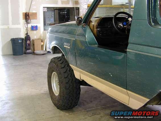 Green 1989 Ford Bronco side view with large off-road tire