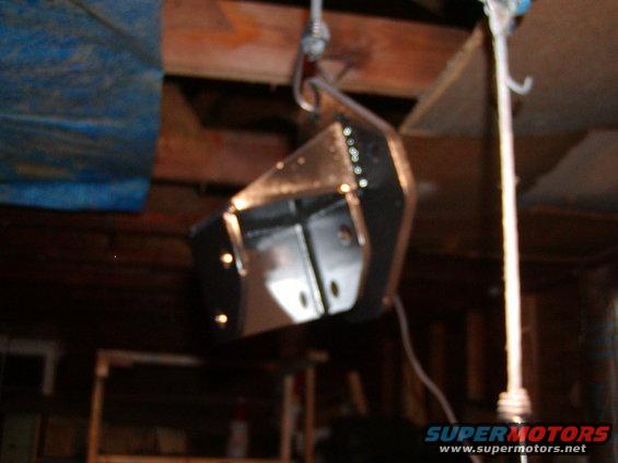 black metal suspension component hanging from a hook