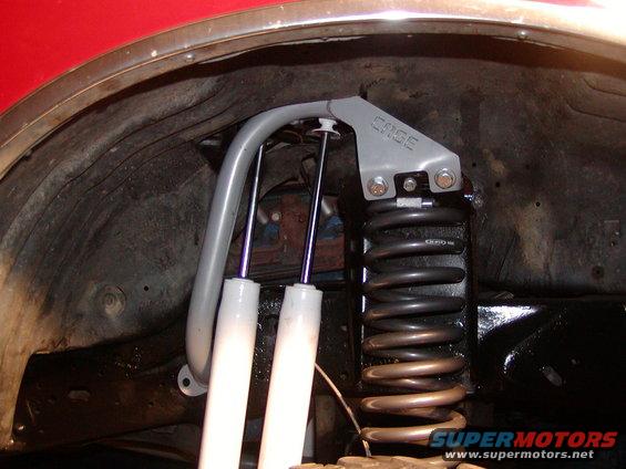 Close-up of suspension parts, including shocks and a coil spring, with a gray bracket labeled 'CASE'