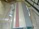 1989 Ford Bronco - Car hood panel with red stripe, possibly for a Ford Bronco, seen in storage.