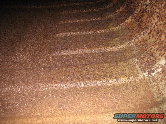 Interior view of heavily rusted metal with horizontal ridges