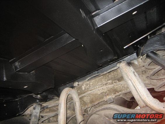 Underside of vehicle showing black undercoating and exhaust pipes
